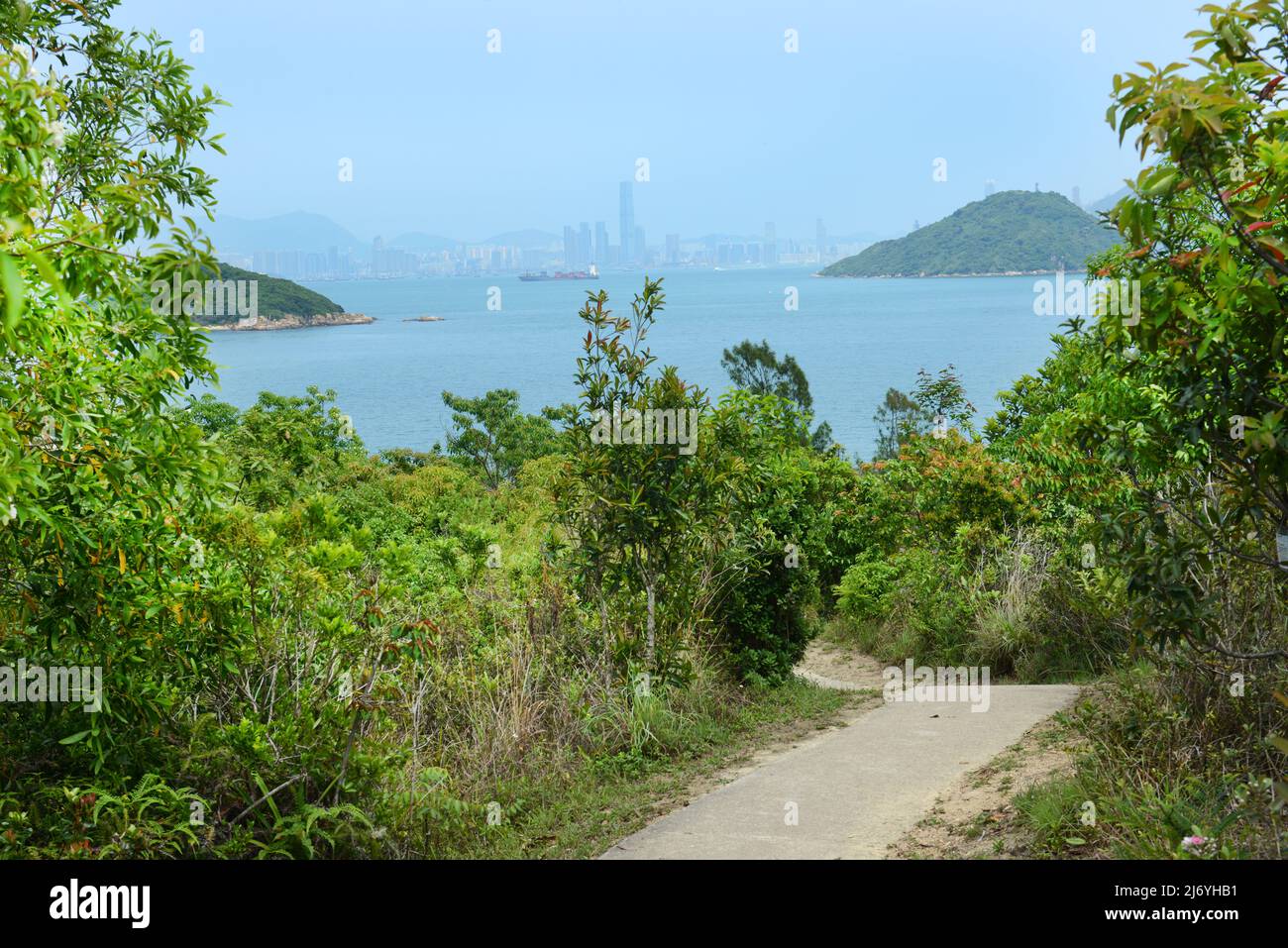 Escursioni a piedi in famiglia a Peng Chau con viste lontane del centro della città di Hong Kong. Foto Stock
