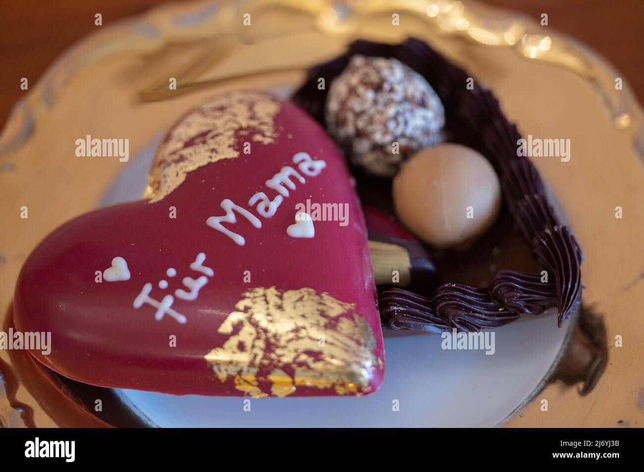 03 maggio 2022, Hessen, Francoforte sul meno: 'For Mum' è scritto su un cuore di cioccolato presso la fabbrica di cioccolato 'Michis Schokoatelier', che serve come scatola commestibile per cioccolatini. La Festa della mamma è il 8 maggio. Foto: Sebastian Gollnow/dpa Foto Stock