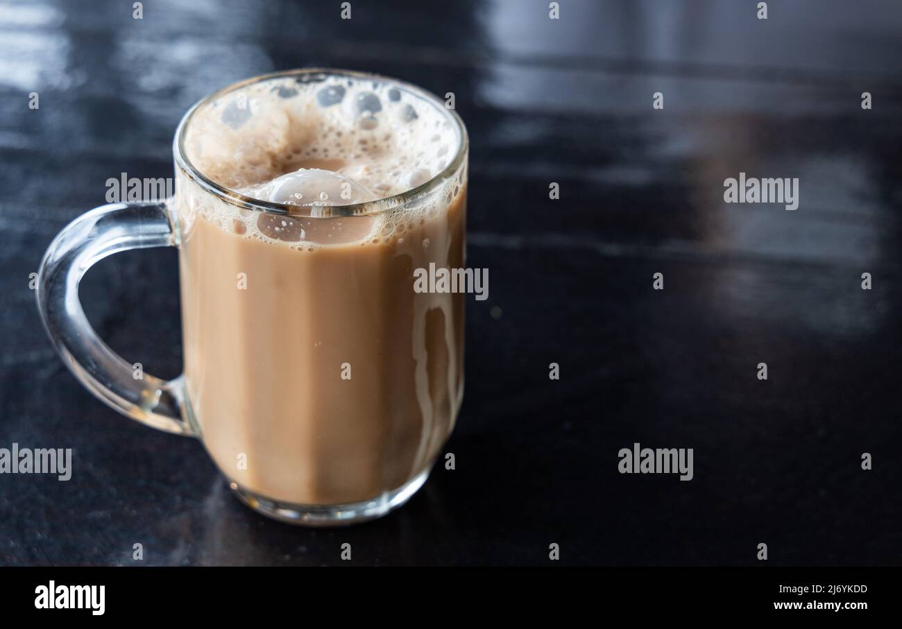 Tarik, viene infuso di tè nero con latte servito in spesse schiuma. Bevande popolari in Malesia Foto Stock