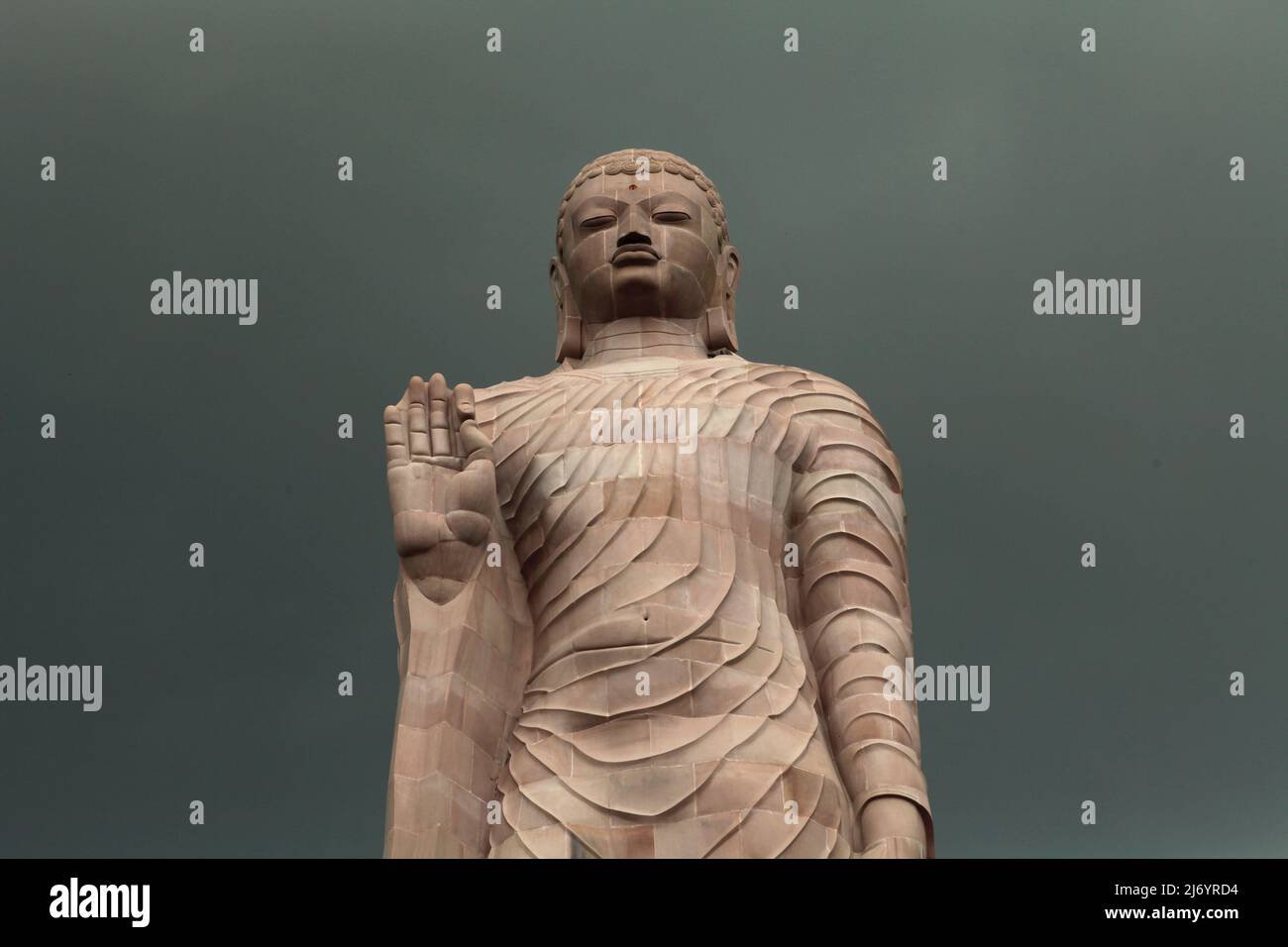 Una statua in pietra arenaria alta 80 piedi del Buddha in piedi a Sarnath alla periferia di Varanasi, Uttar Pradesh, India. Costruita dal 1997 al 2011, la statua fu il risultato di uno sforzo congiunto tra Thailandia e India. Foto Stock