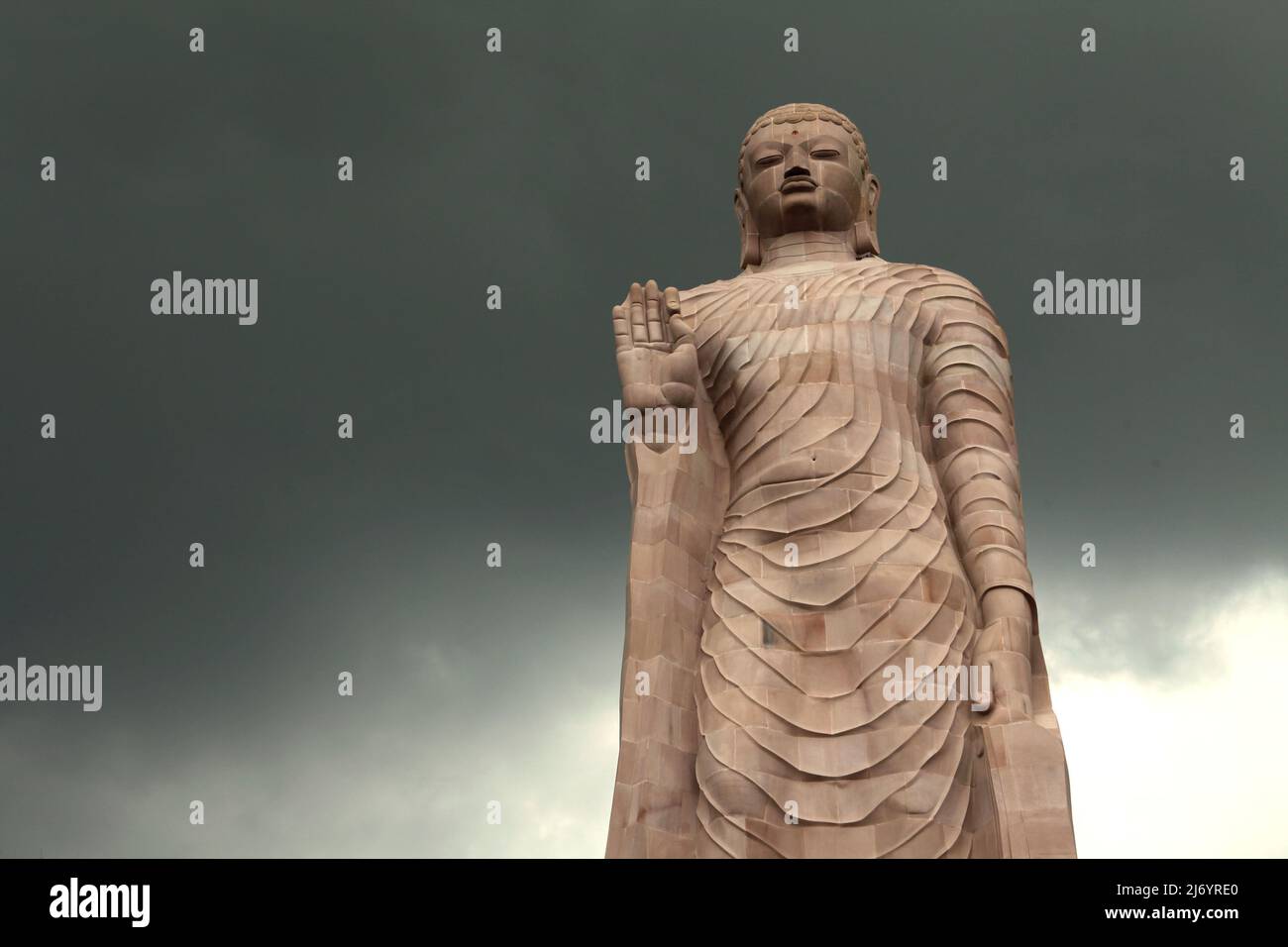 Una statua in pietra arenaria alta 80 piedi del Buddha in piedi a Sarnath alla periferia di Varanasi, Uttar Pradesh, India. Costruita dal 1997 al 2011, la statua fu il risultato di uno sforzo congiunto tra Thailandia e India. Foto Stock