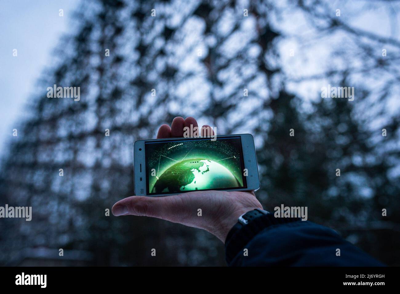 19 febbraio 2018, Pripyat, Ucraina: Resti della Guerra fredda. Un display telefonico mostra come funziona lo scudo missilistico Duga dell'ex Unione Sovietica. Sullo sfondo il radar Duga. La HBO, con la sua serie Chernobyl, è riuscita ad ottenere una grande percentuale di persone in tutto il mondo interessate al più grave incidente nucleare della storia, in misura tale che migliaia di turisti vengono in Ucraina per imparare di persona sulle conseguenze della tragedia e prendere qualche souvenir. Con la sua serie Chernobyl, HBO è riuscito ad ottenere una grande percentuale di persone interessate al nucleare a più grave Foto Stock