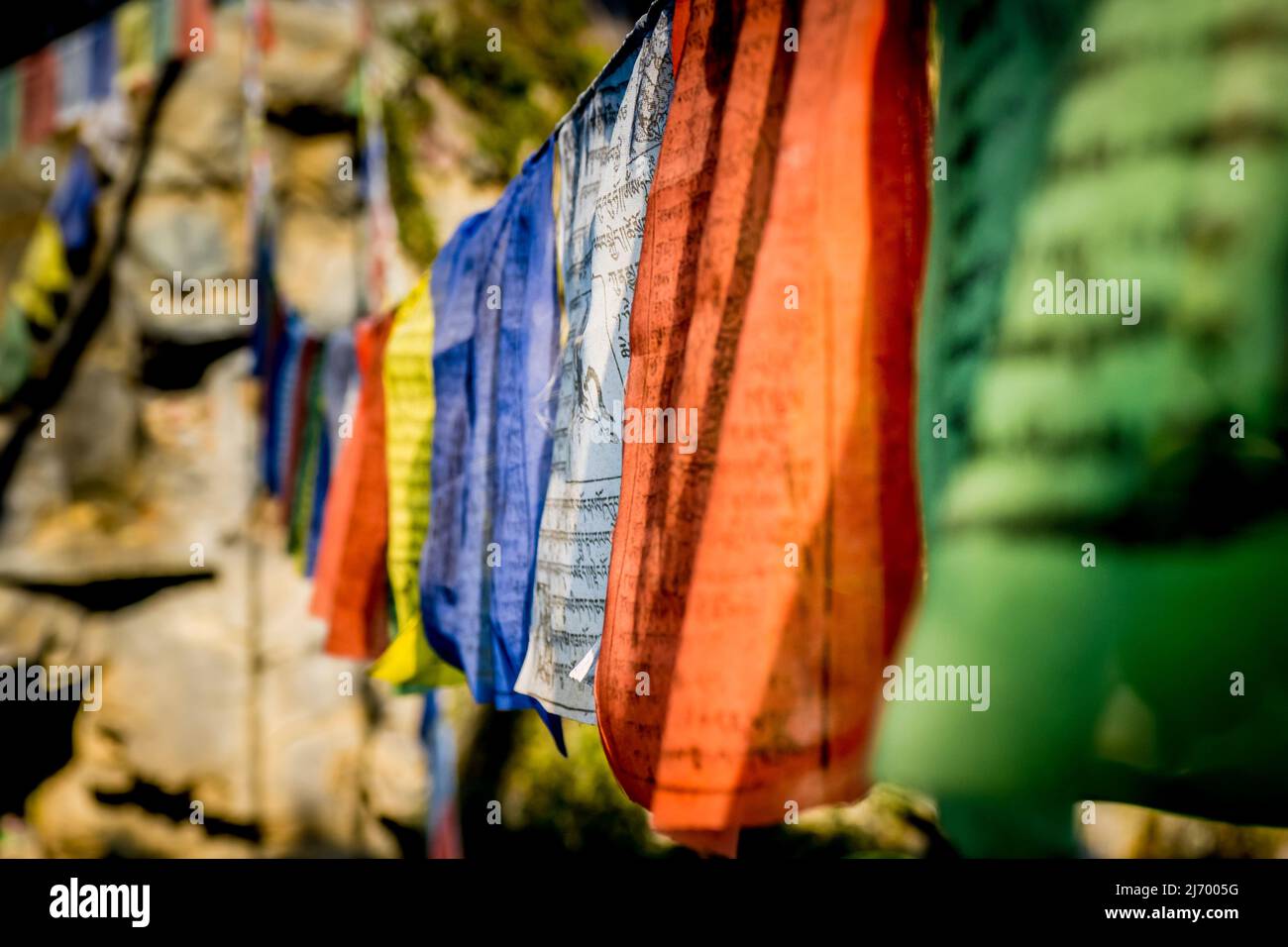 vista ravvicinata delle bandiere di preghiera tibetane lungo un sentiero nell'himalaya per benedire la campagna circostante. Foto Stock