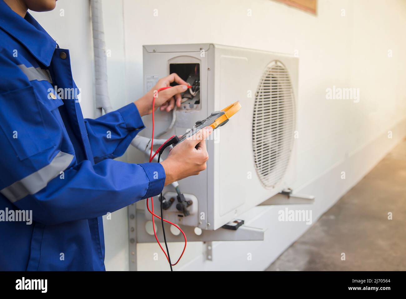 Il tecnico controlla il funzionamento dell'aria condizionata, rilevando perdite di refrigerante. Foto Stock