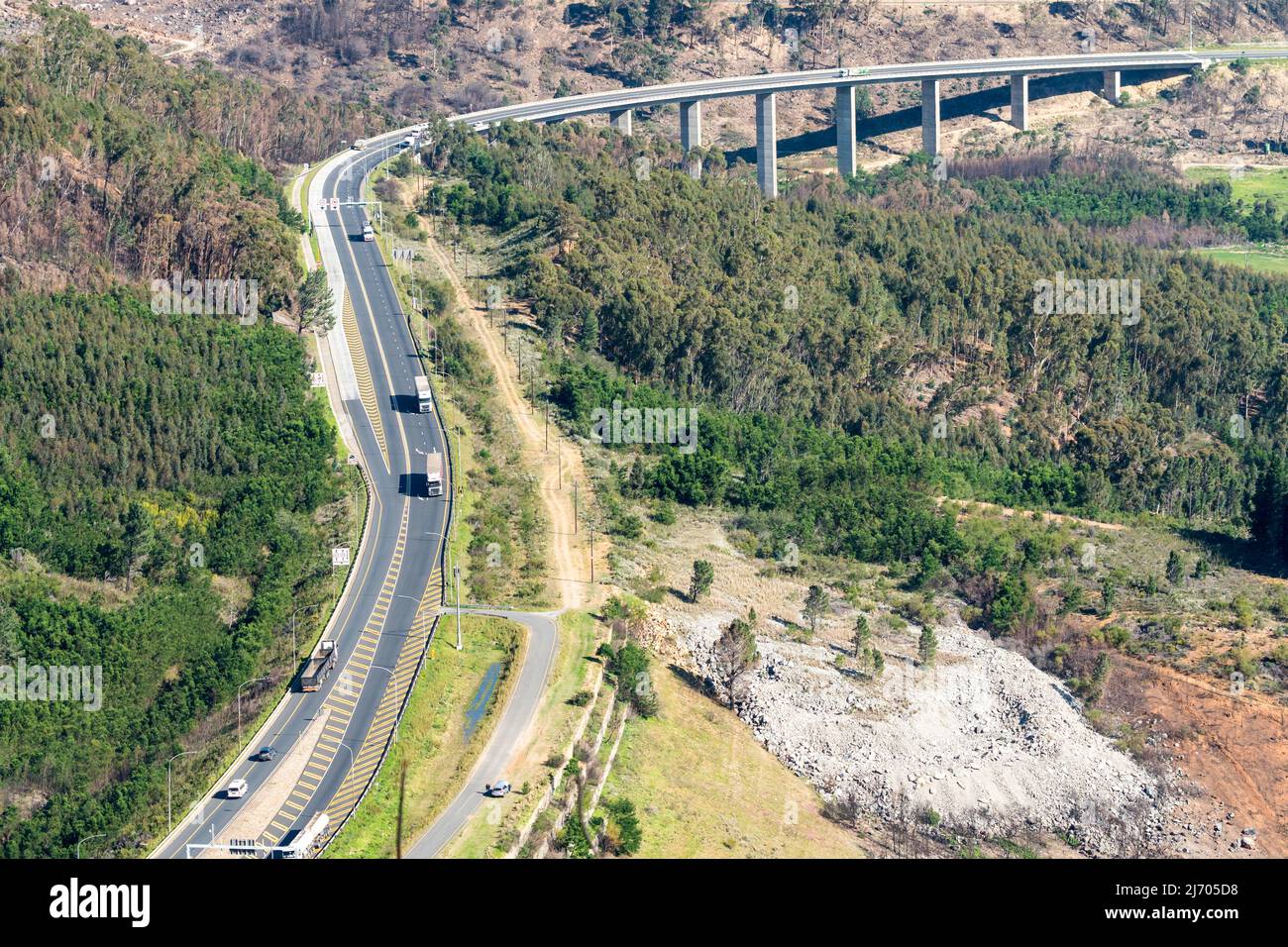 Vista aerea, guardando verso il basso sull'autostrada N1 e ponte sopraelevato che conduce al tunnel Huguenot in Western Cape, Sud Africa Concept Infrastructure Foto Stock