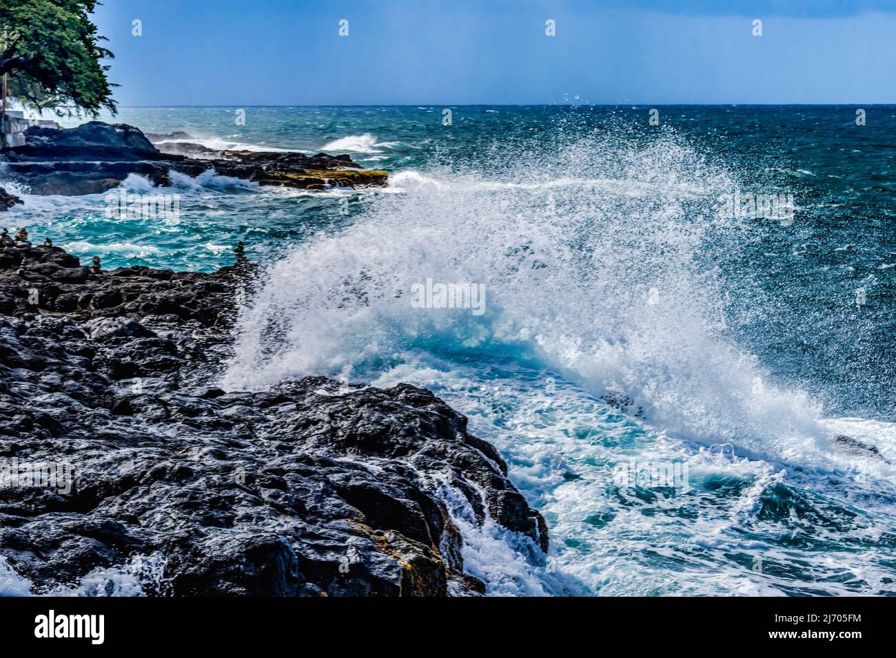 Colorati Arahoho Blowhole Black Lava Rocks onde Blue Water Tahiti Island Polinesia francese. Blowhole è un geyser marino, il surf oceanico entra in pietra g Foto Stock