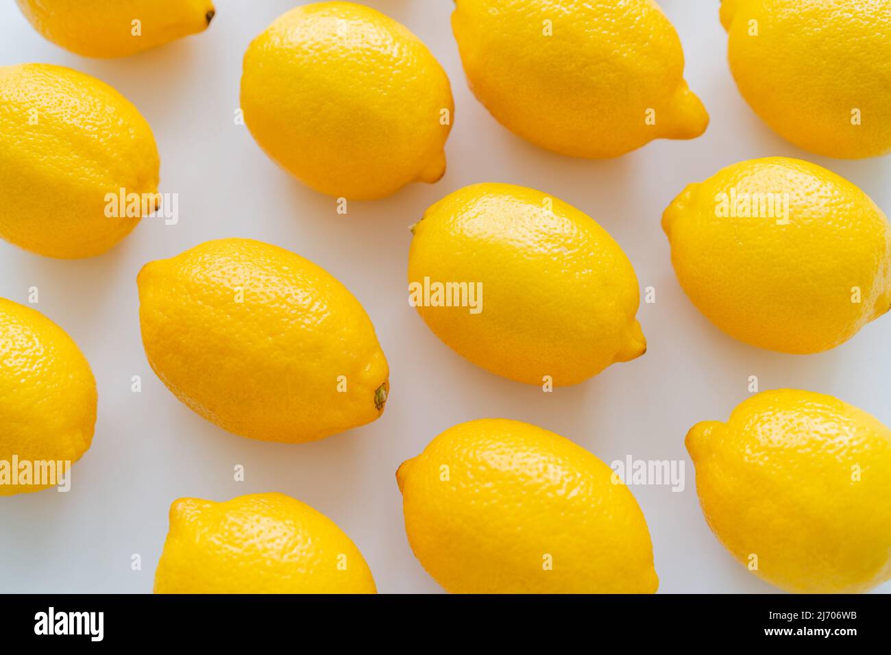 Posa piatta di limoni luminosi su sfondo bianco Foto Stock