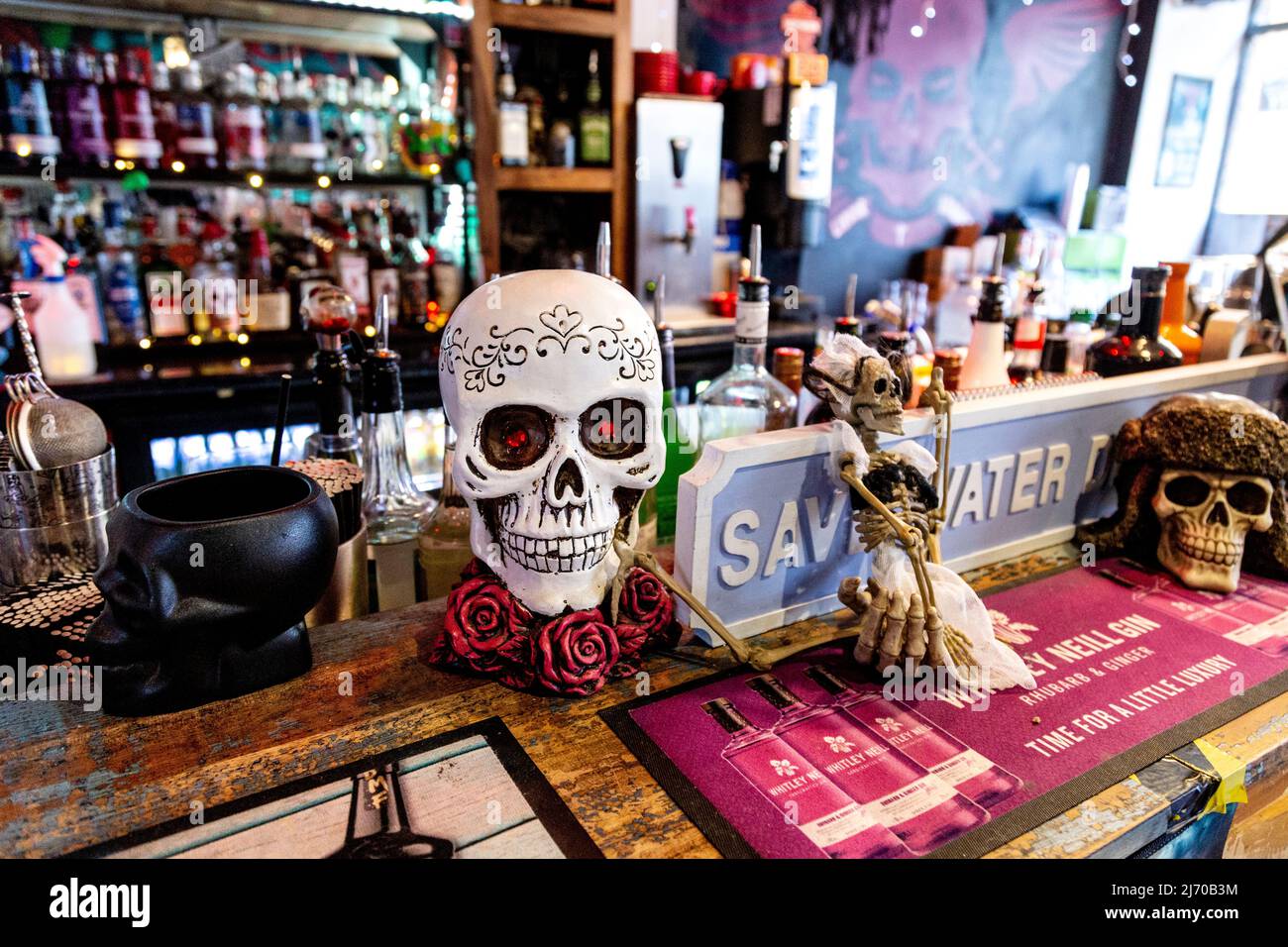 Bancone bar e decorazioni craniche presso Liquor & Loaded, King's Lynn, Norfolk, UK Foto Stock