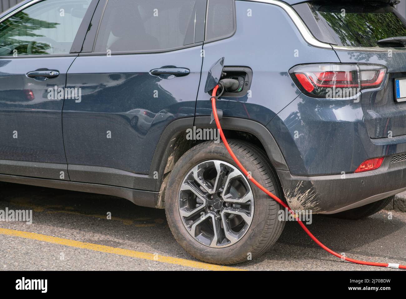 auto elettrica: il plug-in con cavo trasporta l'alimentazione elettrica in modo da poter ricaricare rapidamente le batterie del motore elettrico. Foto Stock