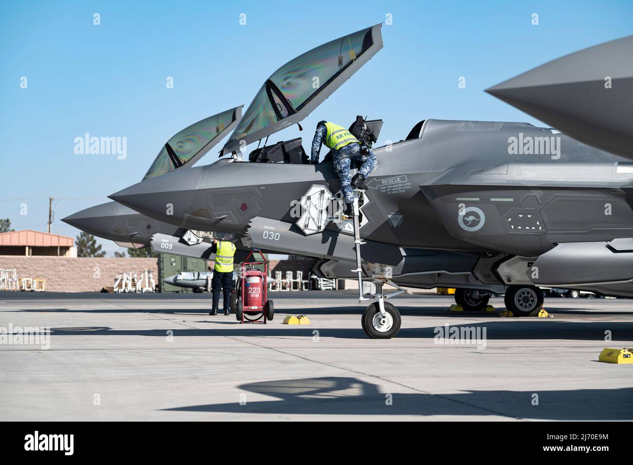 Gli equipaggi di manutenzione della Royal Australian Air Force (RAAF) preparano due F-35A Lightning II per una missione di addestramento alla base dell'aeronautica di Nellis, Nevada, 27 aprile 2022. I F-35s del RAAF sono alla Nellis formazione con gli Stati Uniti 4th e 5th generazione di aeromobili per aumentare l'interoperabilità. (STATI UNITI Air Force foto di William R. Lewis) Foto Stock