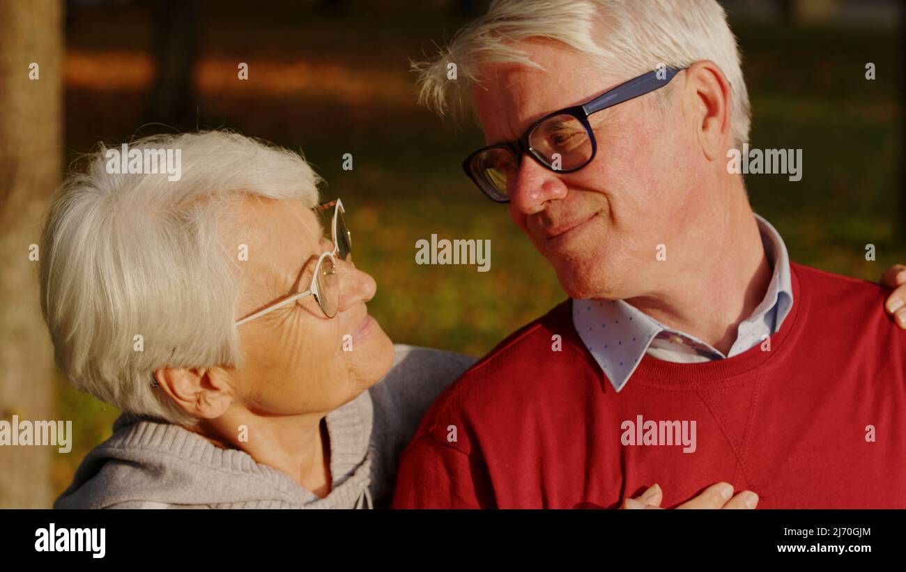 Primo piano ritratto esterno di due anziani caucasici pensionati - uomo e donna - guardando l'un l'altro negli occhi. Felice matrimonio lungo. Foto di alta qualità Foto Stock