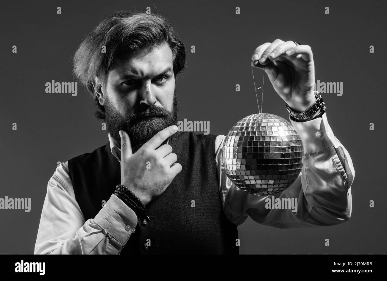 L'uomo maturo bearded tiene la sfera dorata della discoteca, concetto di invito della festa Foto Stock