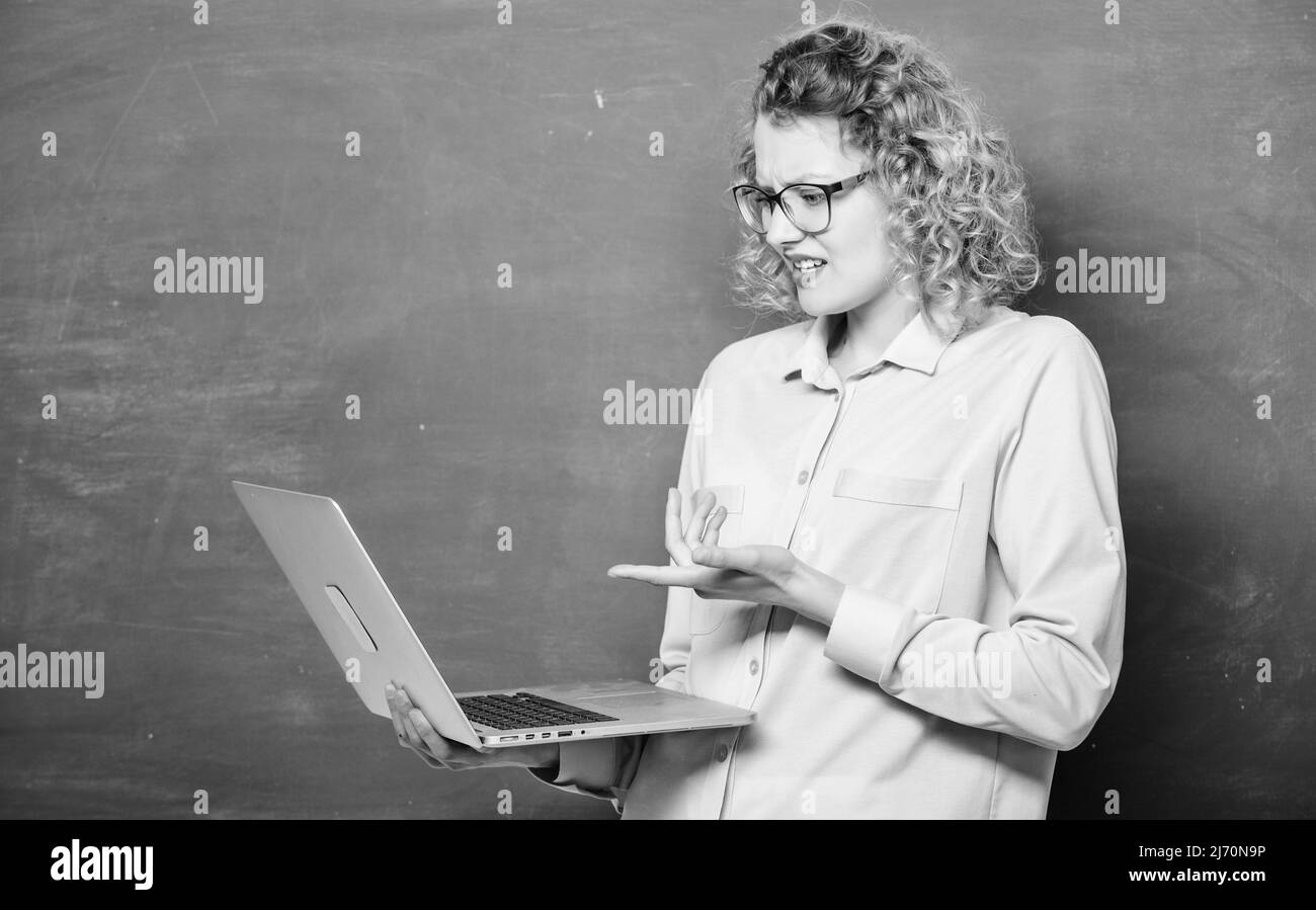 Scuola online. Studiare online. Processo remoto. Notebook docente ricerca informazioni sfondo lavagna. Donna laptop che naviga in internet. Studente STEM Foto Stock