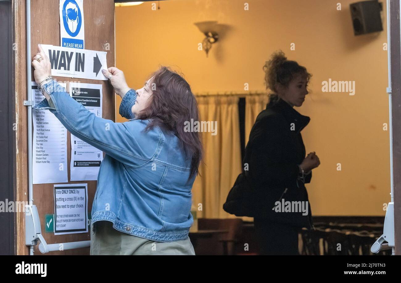 Uno staff elettorale appone un cartello al Bardswell Social Club, Brentwood Essex, che è il seggio elettorale per le elezioni comunali. Il Regno Unito ha oggi le elezioni del consiglio locale quando gli elettori eleggeranno i consiglieri locali. I risultati delle elezioni sono un importante indicatore di opinione politica. Le stazioni di polling sono allestite in aree locali chiamate Wards basate su piccole aree geografiche. Foto Stock