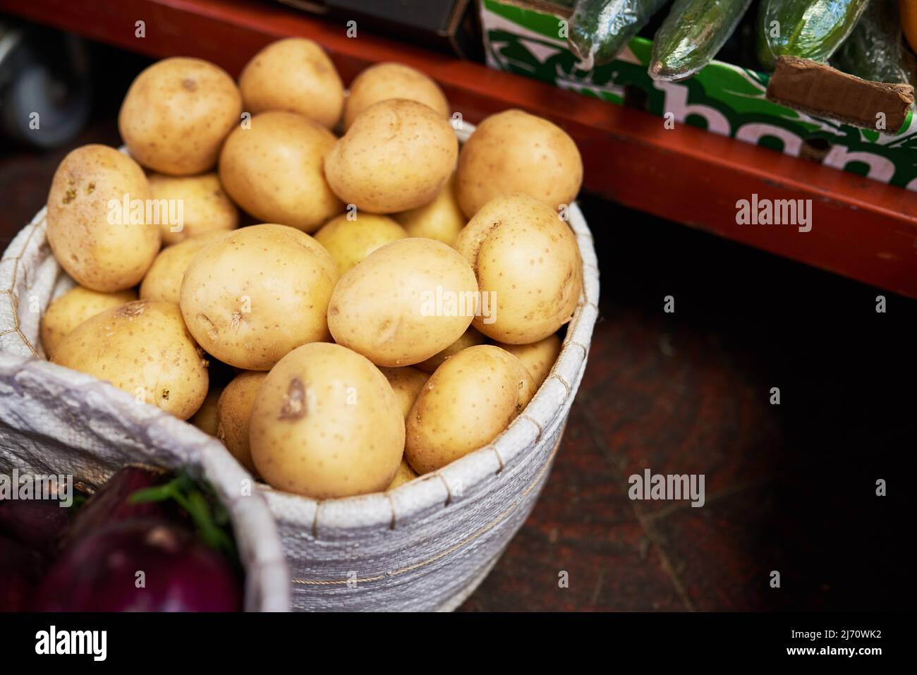 Un cestino di patate in un mercato Foto Stock