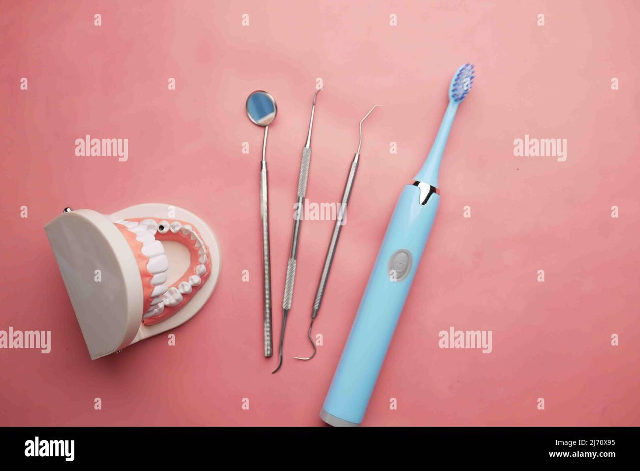 modello dentistico in plastica su sfondo rosa Foto Stock