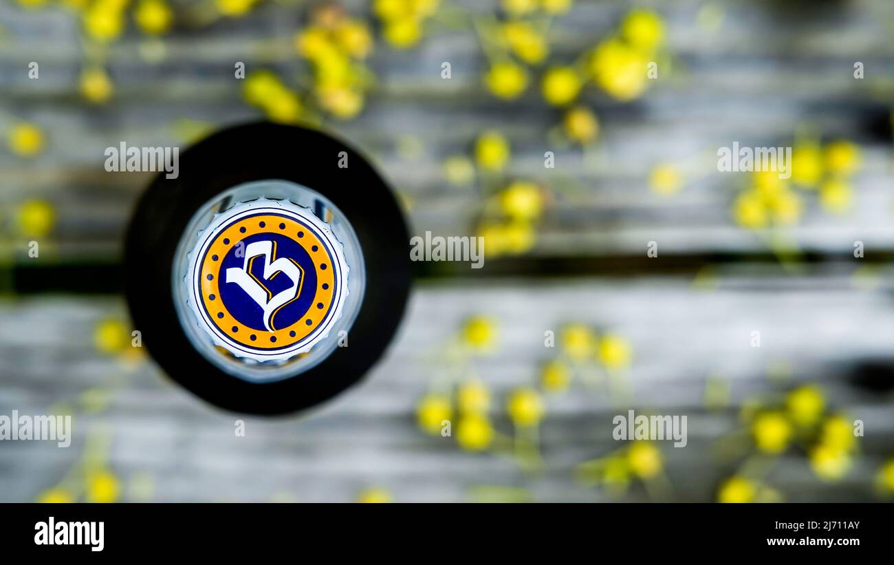 NORWALK, CT, USA - 4 MAGGIO 2022: Bottiglia di birra non alcolica Buckler importata dall'Olanda su un tavolo da giardino all'esterno coperto da inquinamento degli alberi allo sprin Foto Stock