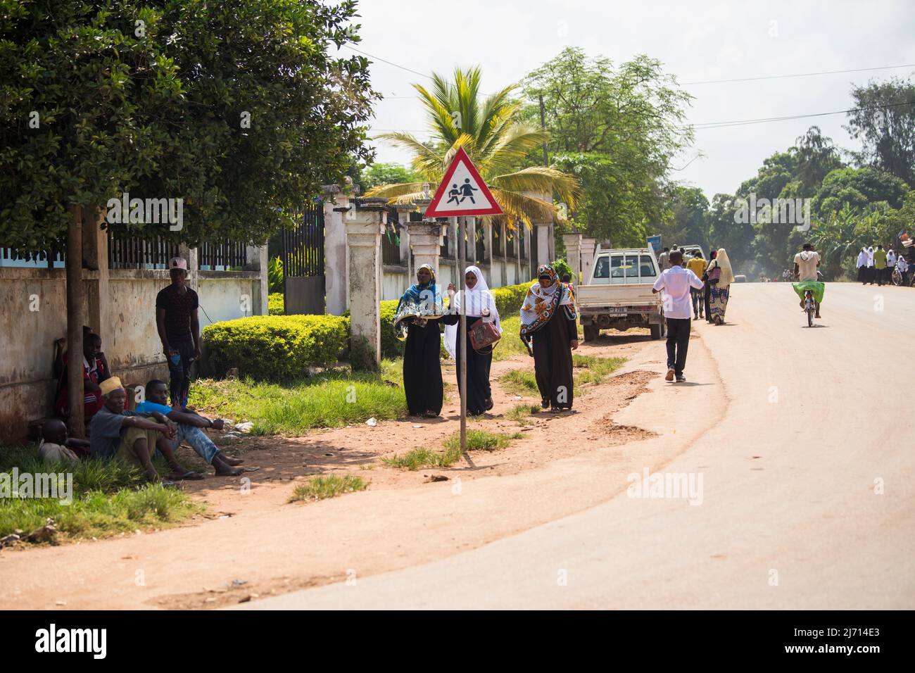 Zanzibar City, Tanzania - Maggio 01,2022: Street view della solita vita quotidiana della popolazione locale di tutte le età che si svolge lungo la strada sull'isola di Zanzibar Foto Stock
