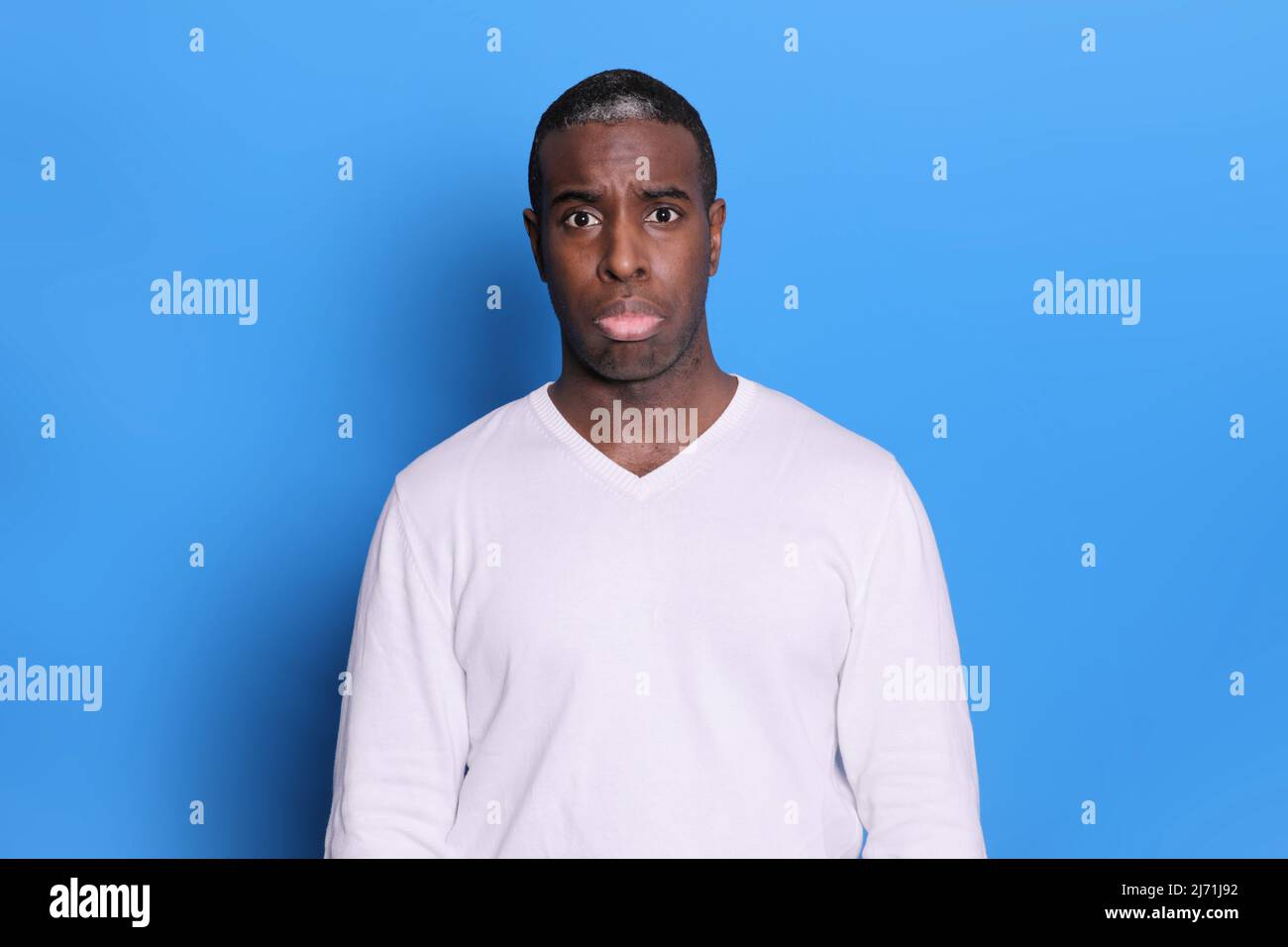 Triste uomo nero doloroso guarda la macchina fotografica con espressione miserabile Foto Stock