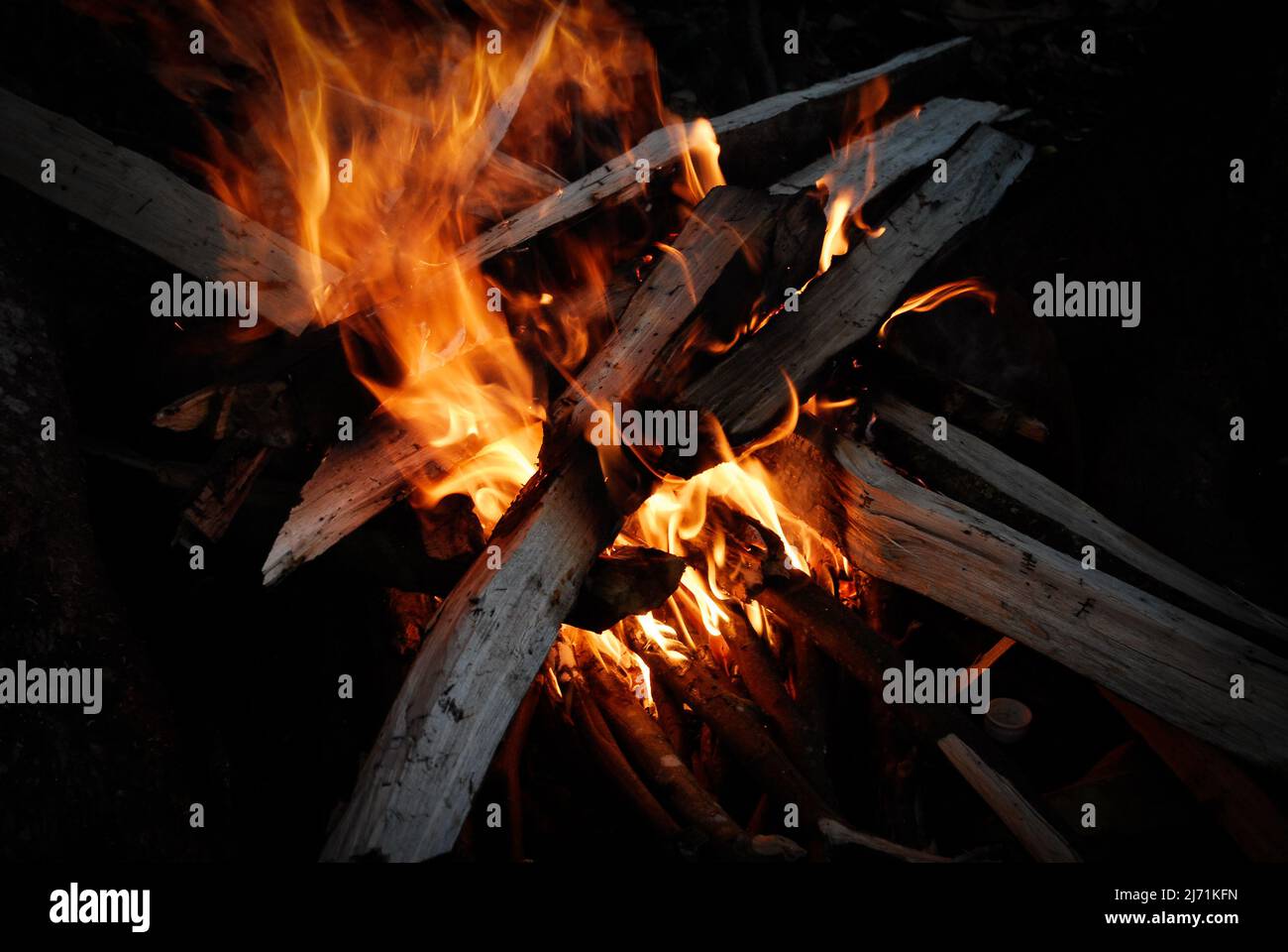 Fiamme di legno che brucia nelle tenebre Foto Stock