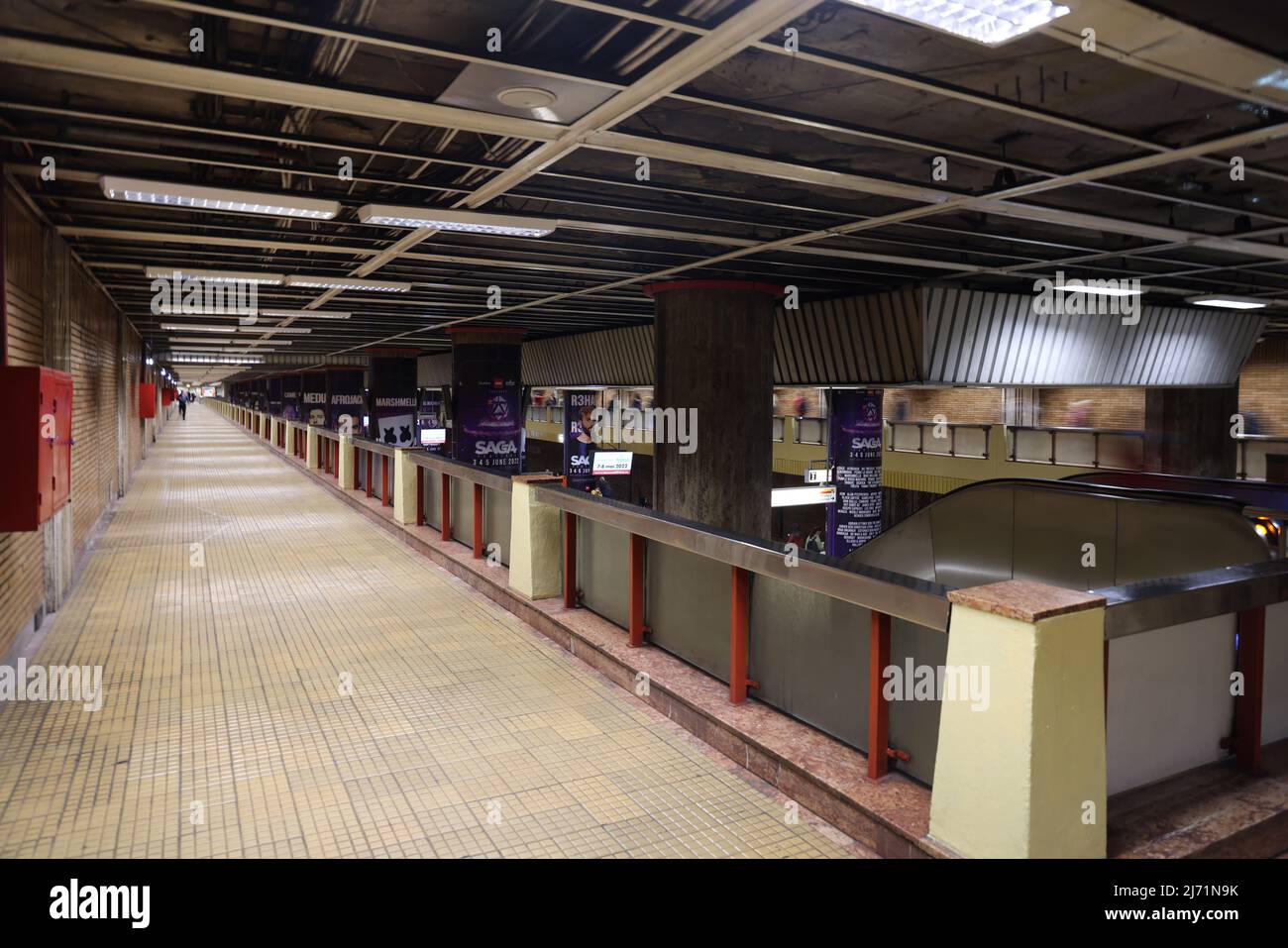 Lungo passaggio pedonale per il trasferimento tra le linee della metropolitana nella stazione della metropolitana Piata Unirii a Bucarest, Romania, che ha un'architettura brutalista Foto Stock