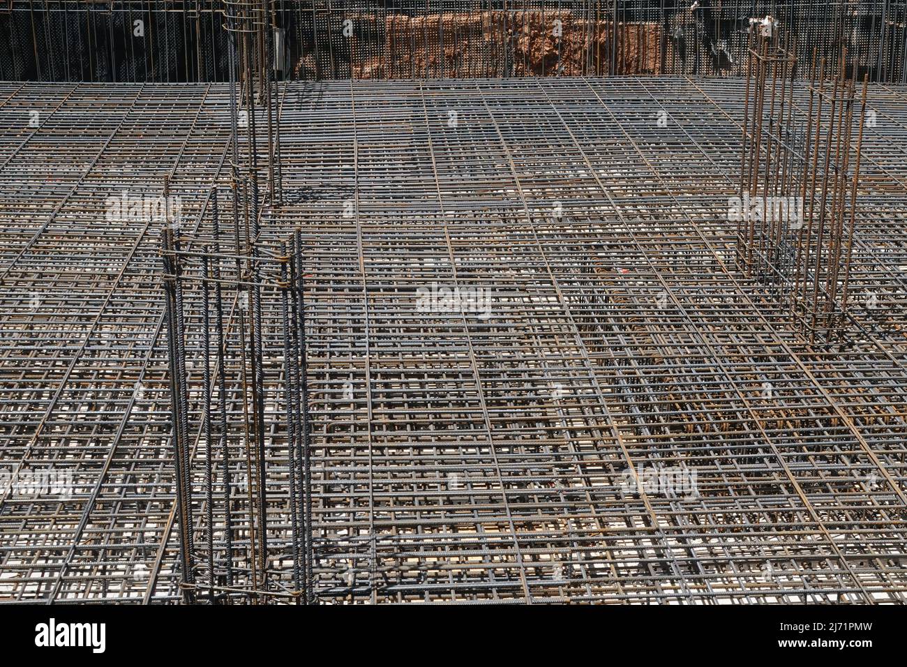 Costruzione di fondamenta con barre di rinforzo in acciaio in cantiere. Foto Stock