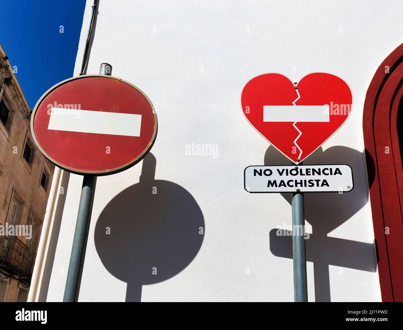 Zwei Verkehrsschilder werfen Schatten, Einfahrt verboten, gebrochenes Herz, Aufschrift No Violencia Machista in einer Kampagne gegen haeusliche Foto Stock