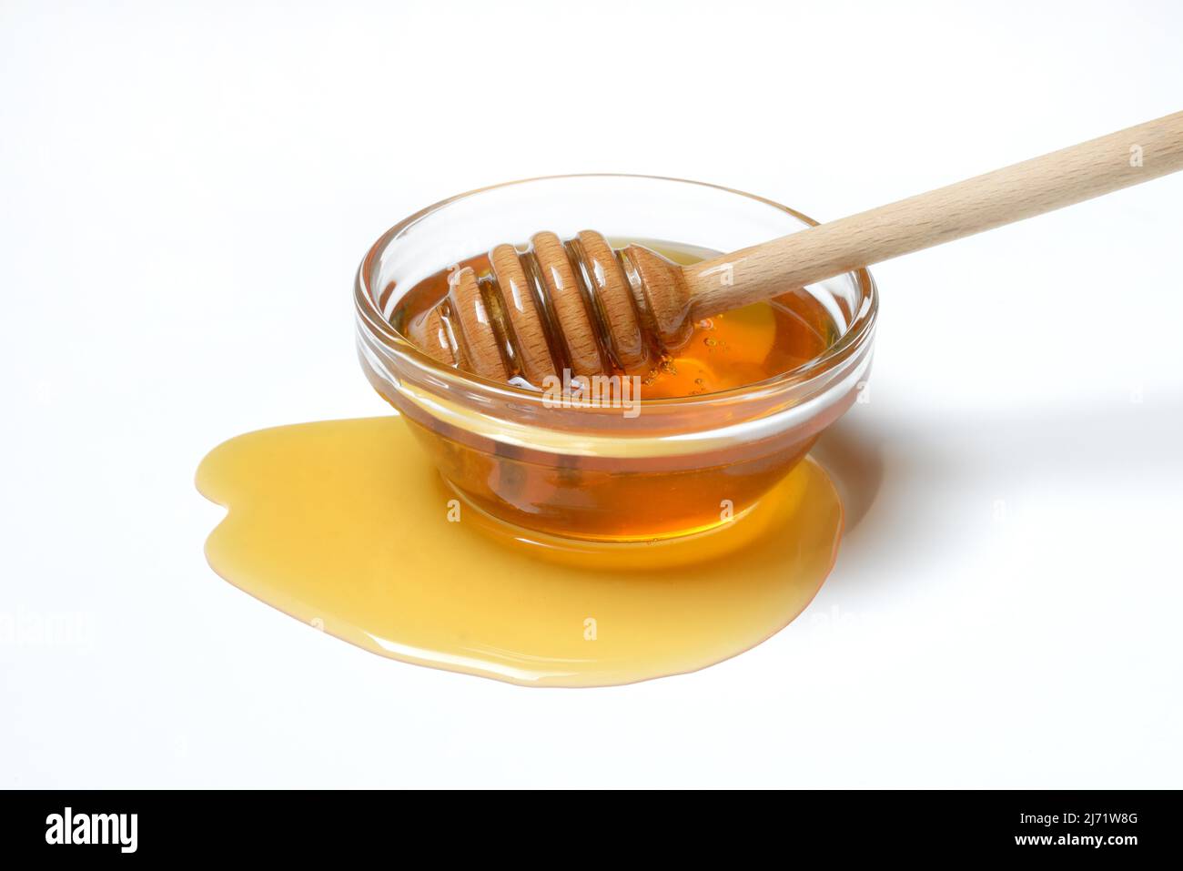 Miele di api con cucchiaio di miele in ciotola, miele di fiori, sfondo bianco Foto Stock