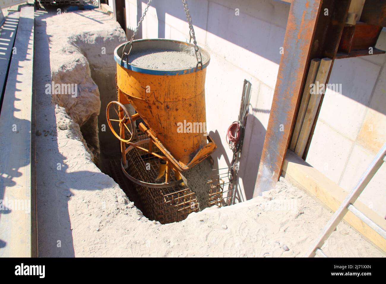 Riempire una fondazione con calcestruzzo attraverso un silo Foto Stock