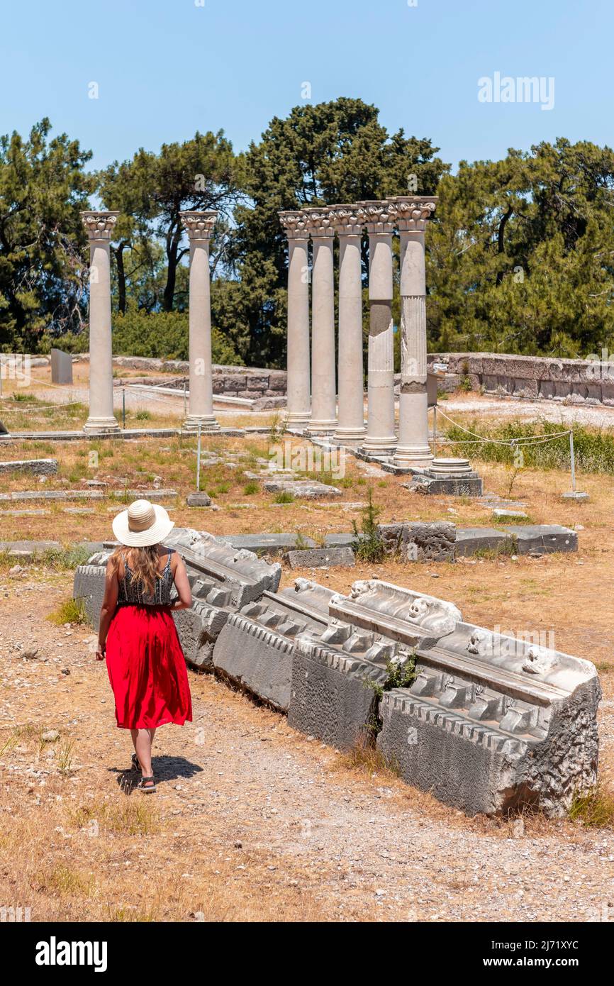 Giovane donna con vestito di fronte alle rovine con colonne, ex tempio, Asklepieion, Kos, Dodecanesi, Grecia Foto Stock