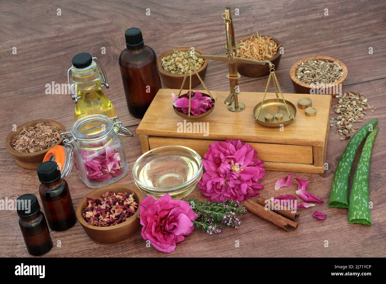 Preparazione di erbe e fiori per il trattamento naturale della pelle a base di piante con pesatrici in ottone e bottiglie di olio essenziale. Trattamento di medicina vegetale naturale Foto Stock
