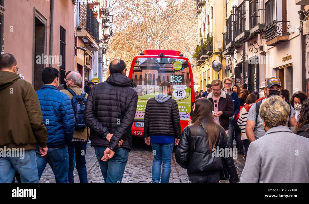 Autobus rosso n 32 che passa attraverso la stretta strada pedonale nel centro di Granada, Andalucia, Spagna Foto Stock