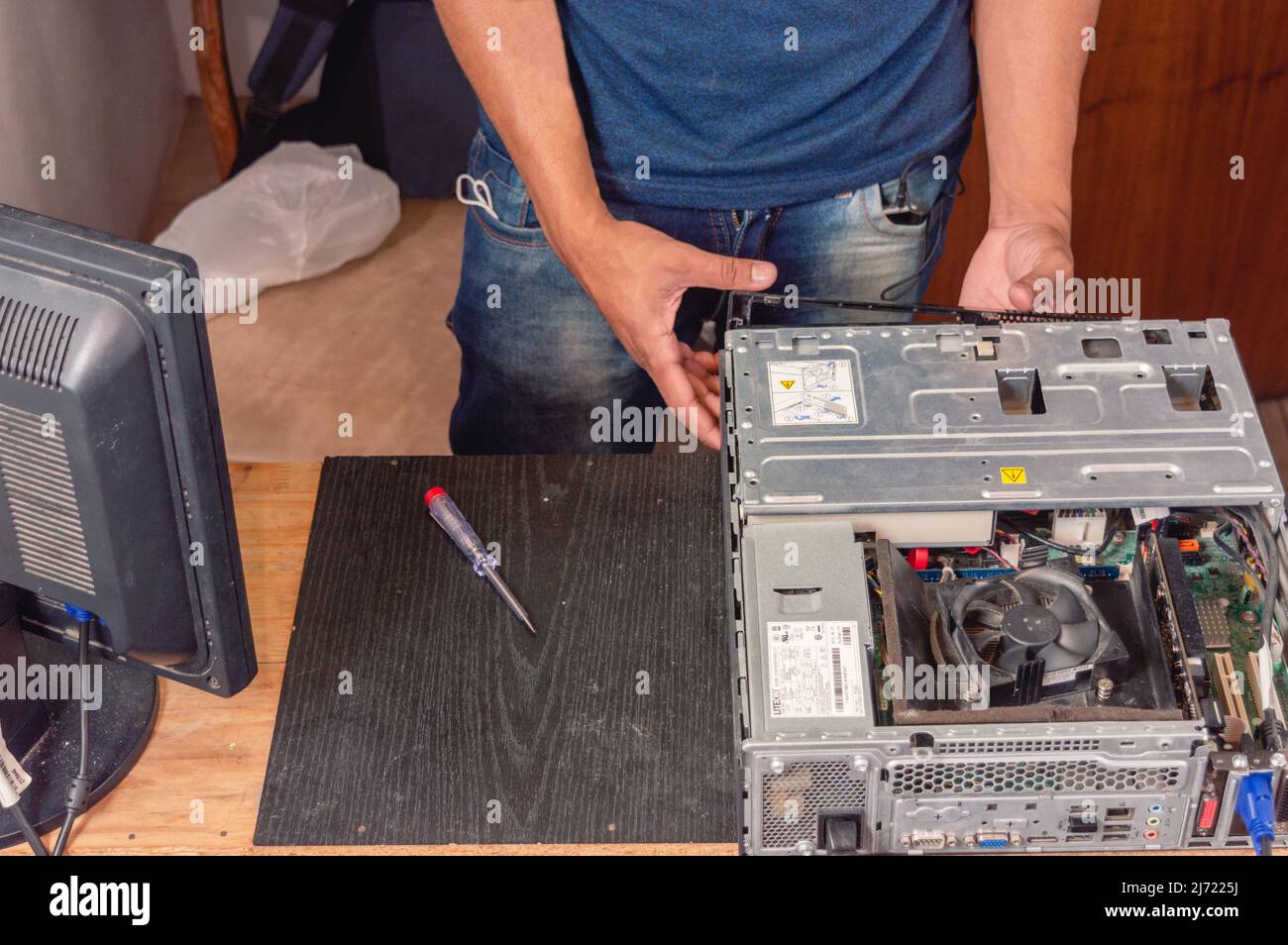 tecnico di elettronica, a casa aprendo il case del computer, lavorando sulla manutenzione, assistenza tecnica e riparazione. Foto Stock