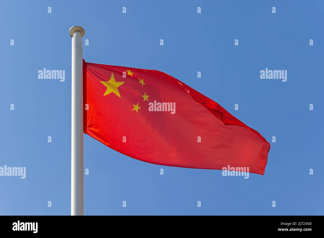 Bandiera nazionale della Cina al giorno del sole del cielo blu Foto Stock