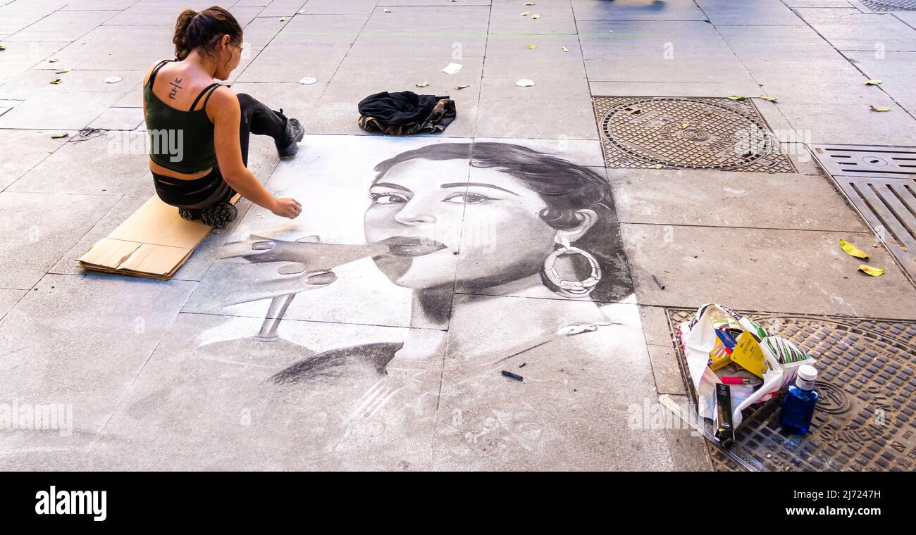 Pittore di strada andaluso femminile che dipinge un ritratto della donna su un marciapiede in un'area pedonale, Siviglia, Andalusia, Spagna Foto Stock