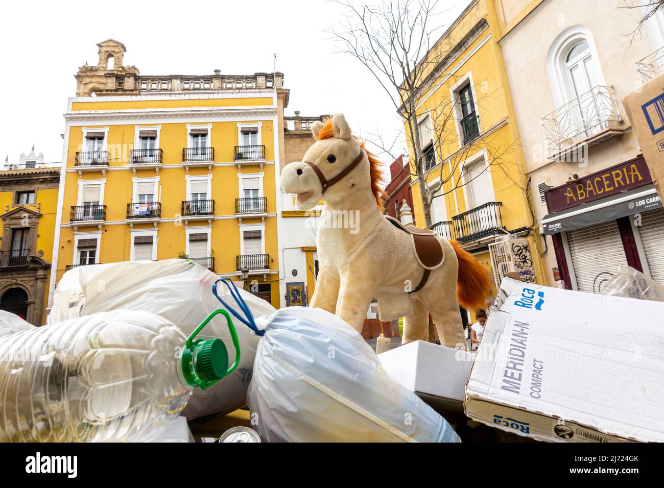 Un giocattolo da cavallo per bambini sulla parte superiore del contenitore dei rifiuti dopo la fiera in Plaza de Monte-Sion, Feria, Siviglia, Andalusia, Spagna Foto Stock