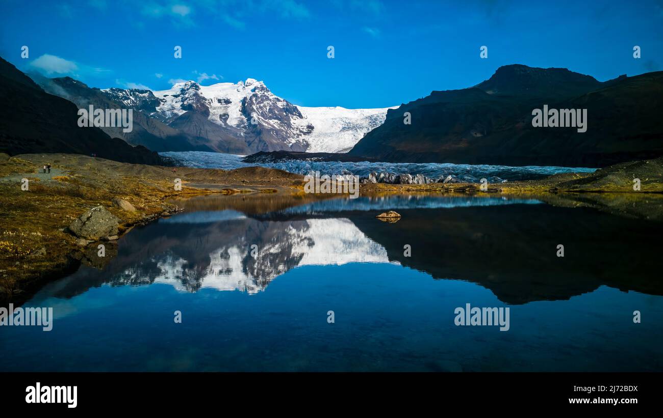 Ghiacciai e montagne riflessi nel lago con cielo blu Foto Stock