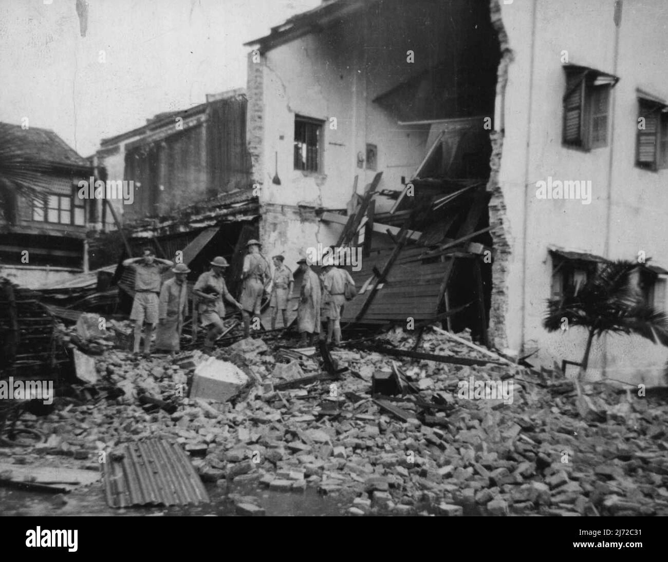 Gli esperti dell'esercito britannico osservano i danni provocati dalla bomba nella città malese settentrionale di Taiping dieci minuti dopo che gli aerei giapponesi si erano rivolti a casa. Questa casa era stata evacuata un giorno prima dalla famiglia cinese di tredici. Gennaio 14, 1947. Foto Stock