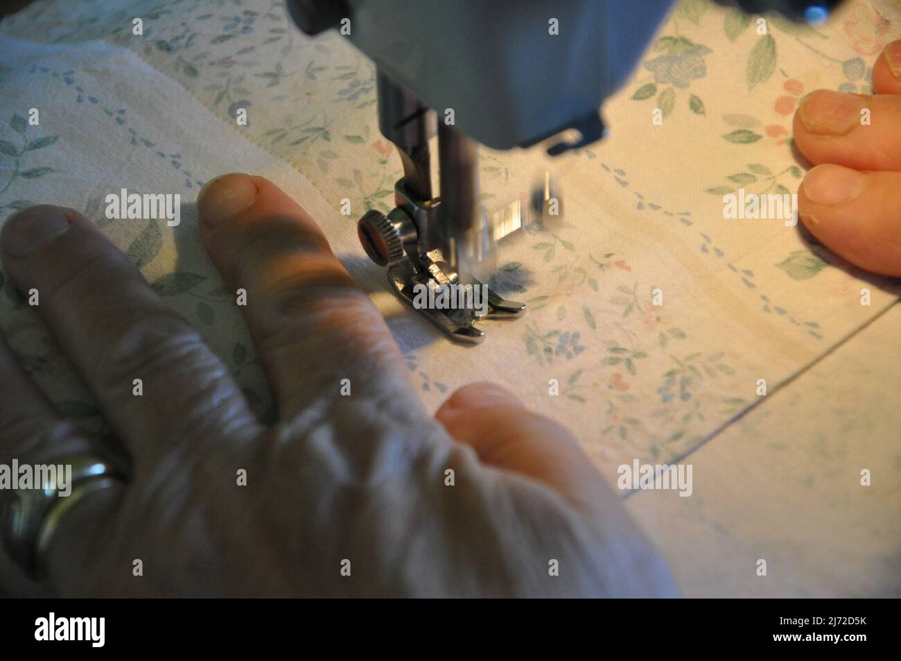 Le mani femminili lavorano su una macchina da cucire. Cucire a mano su una macchina Foto Stock