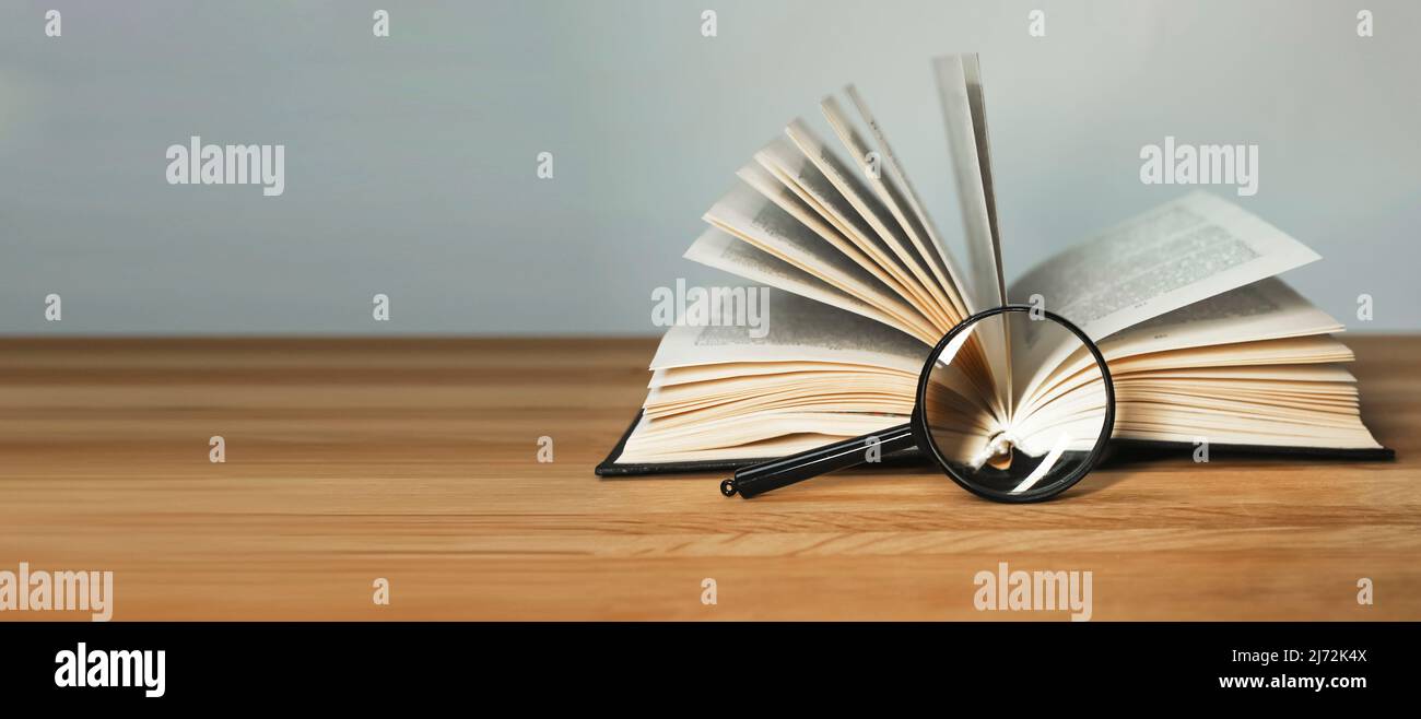 Banner con libro aperto e lente d'ingrandimento. Ricerca di informazioni e analisi approfondita, concetto di conduzione della ricerca. Spazio di copia. Foto di alta qualità Foto Stock