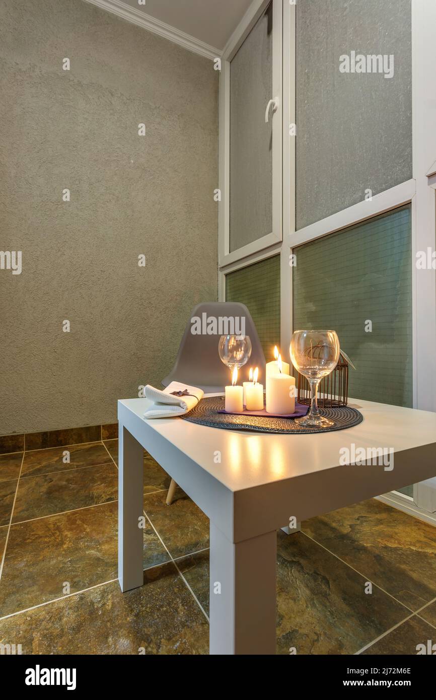 candele bruciate su un tavolo con fiori con bicchieri o frutta, atmosfera intima e romantica Foto Stock