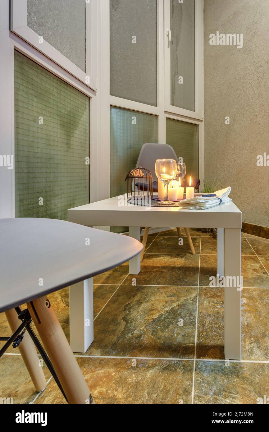 candele bruciate su un tavolo con fiori con bicchieri o frutta, atmosfera intima e romantica Foto Stock