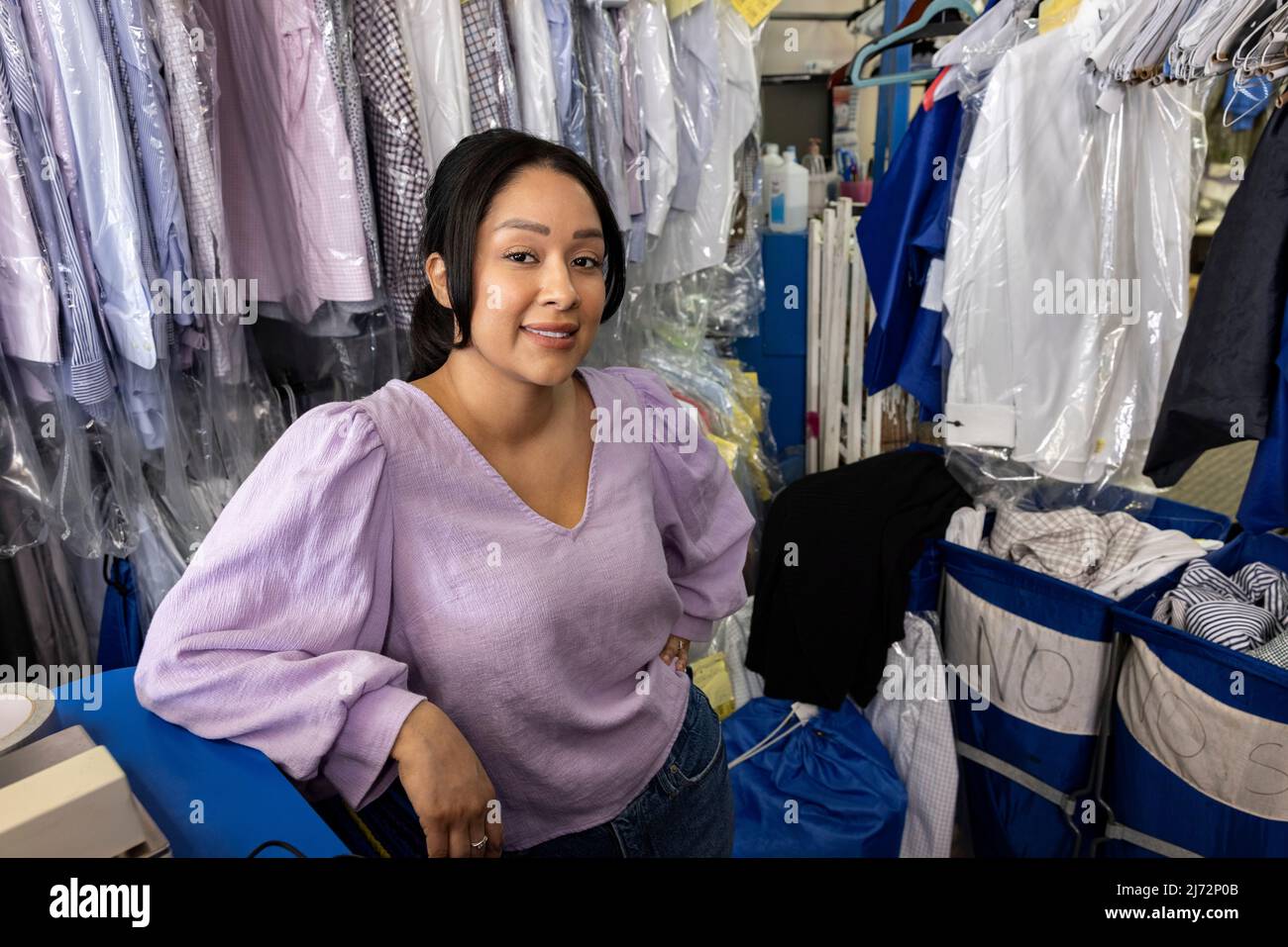 Ritratto ad angolo alto di un giovane ispanico piccolo imprenditore, dry cleaners Foto Stock