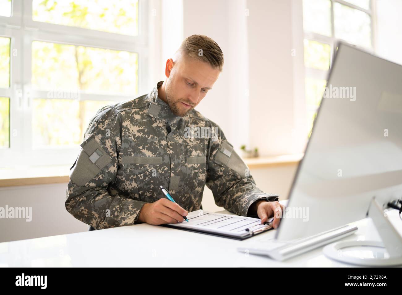 Educazione militare allo studente. Veterano soldato dell'esercito con il calcolatore Foto Stock