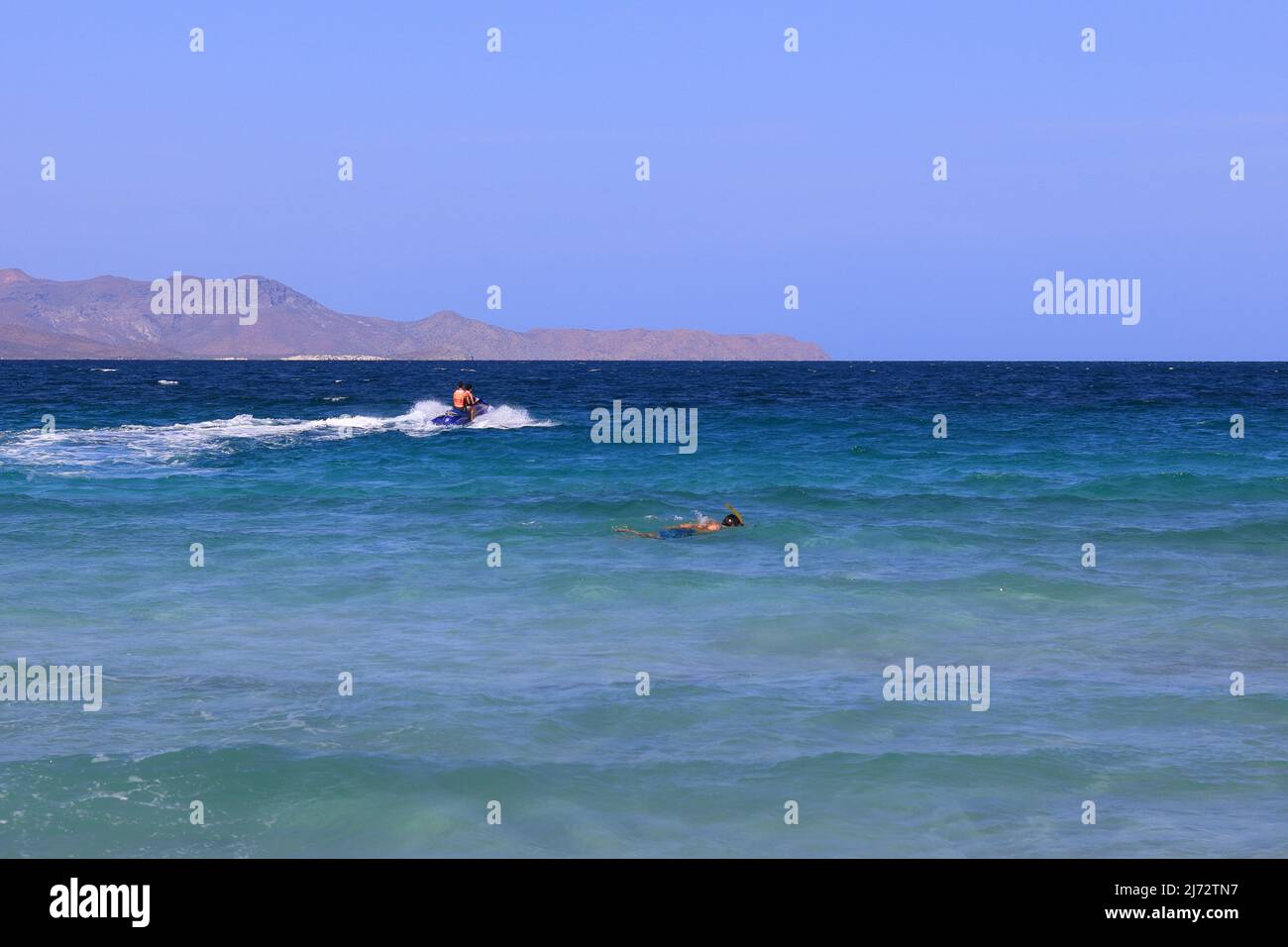 La Paz spiaggia in Messico. Un nuotatore e una moto d'acqua Foto Stock