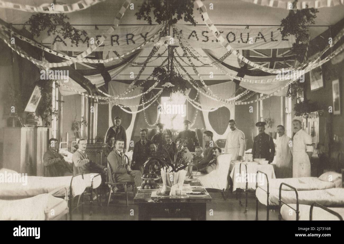 Pazienti dell'esercito britannico e ordini medici nell'ospedale militare con sede a Holmstone Camp, Lydd, Kent. La fotografia è stata scattata a Natale del 1916, durante la prima guerra mondiale. Il reparto è decorato con catene di carta, una bandiera fatta a mano che augura ai visitatori “A Merry Xmas to U all”, bandiere bianche British Royal Navy e altre bandiere degli Alleati, compresa la bandiera nazionale giapponese. Foto Stock