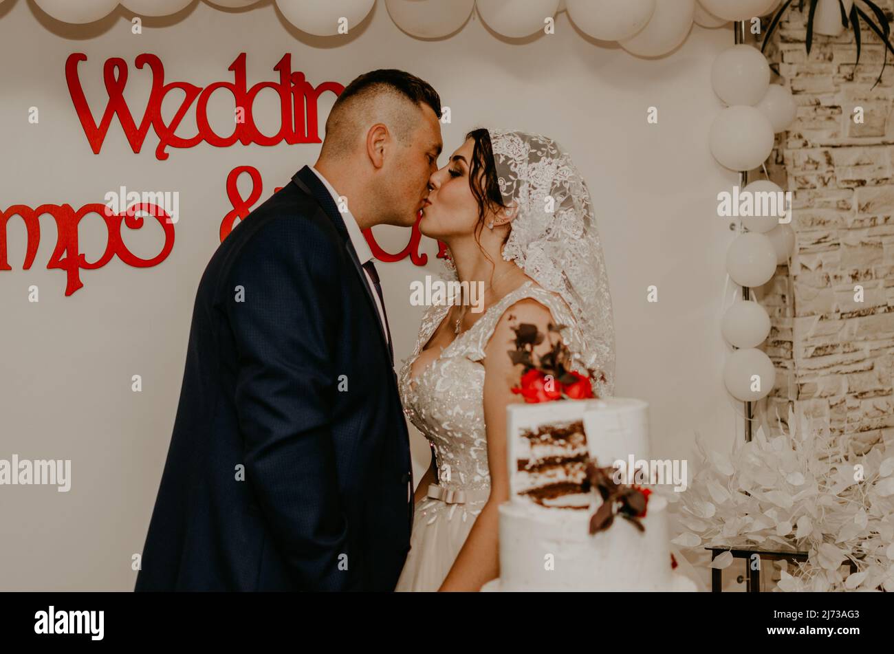 sposare e sposare a matrimonio tagliare il loro grande multi-tiered torta bianca gusto che si nutrì l'uno dall'altro. Tradizione russa Slavica Ucraina Foto Stock