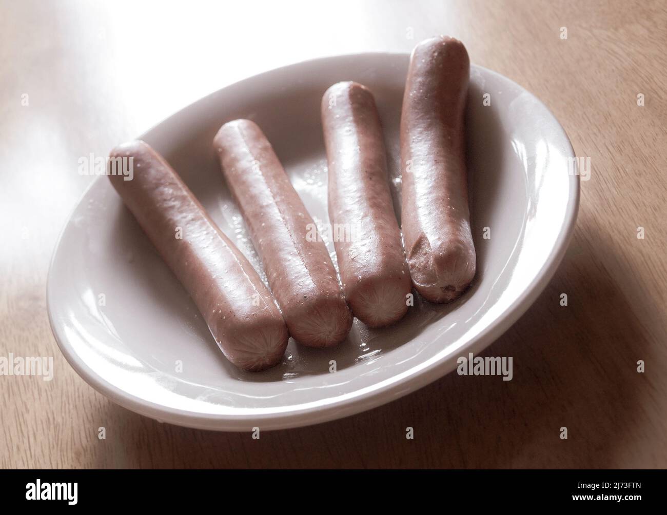 salsicce bollite di hotdog nel piatto sul tavolo Foto Stock