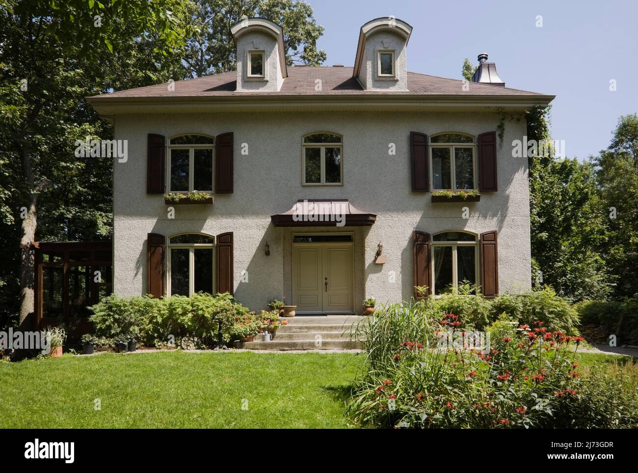 Casa francese a due piani in stile maniero con giardino paesaggistico in estate. Foto Stock