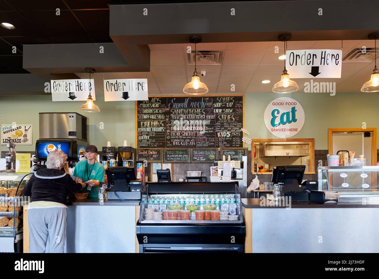 Negozio di specialità gastronomiche o banco di ricevimento con dipendente e cliente al Sweet Creek Farm Market a Pike Road Alabama, USA. Foto Stock